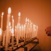 man standing near lighted candles