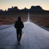 person walking in the center of the road